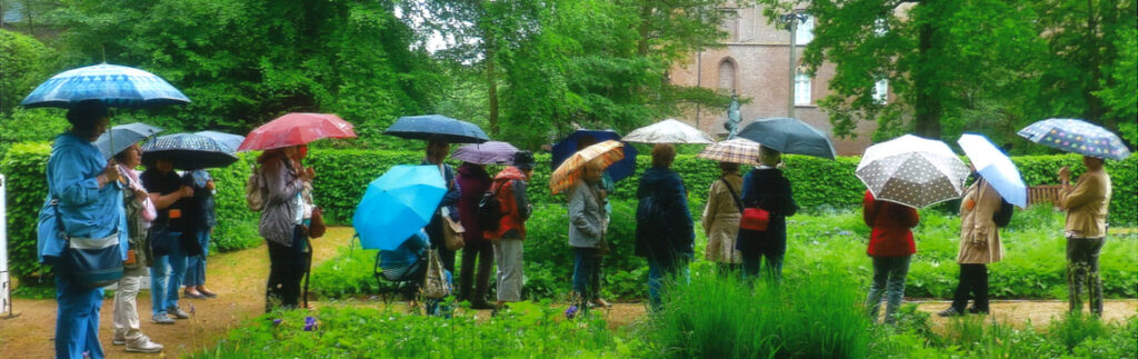 Menschen im Regen stehen vor einem Schloss
