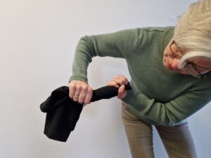 Eine Frau wringt eine Hose aus